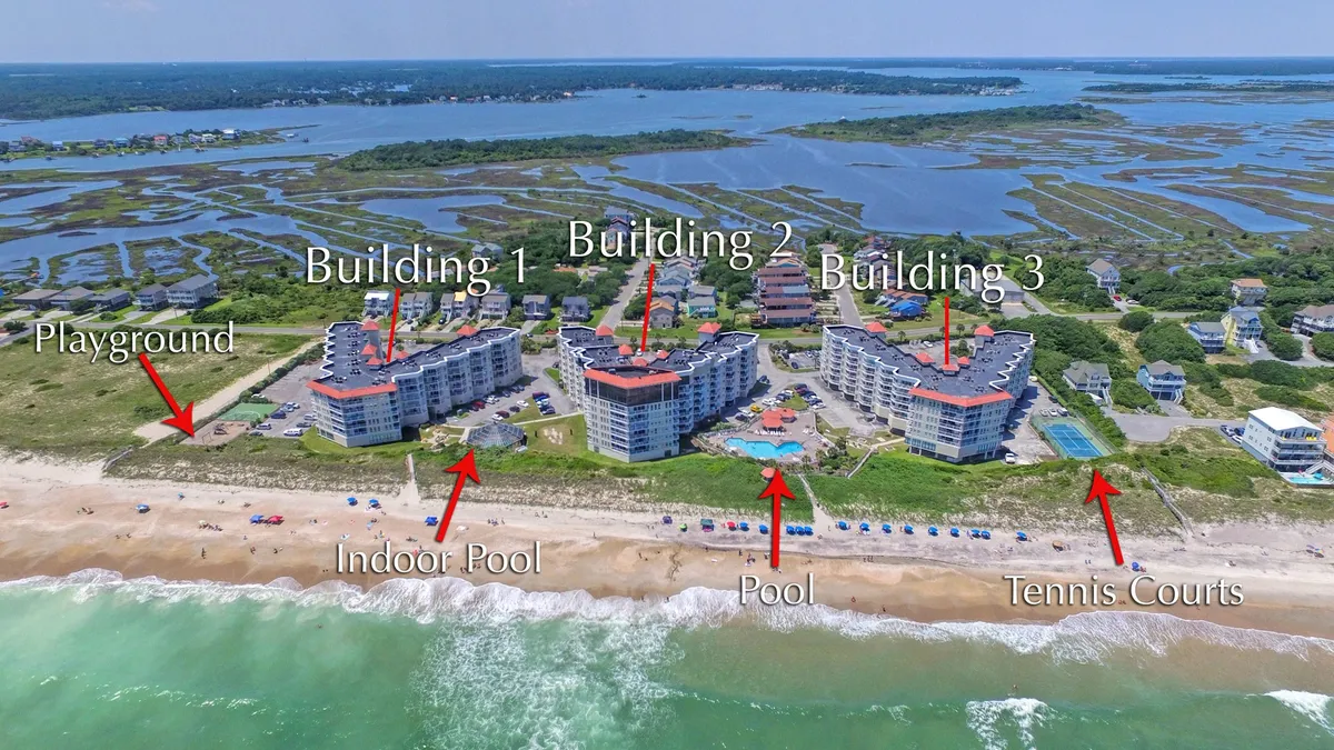 This wide exterior shot captures the resort complex, showcasing multiple pools, tennis courts, playground, and the surrounding buildings. The setting exudes a relaxed, vacation-style atmosphere and hints at a variety of amenities for both recreation and leisure.